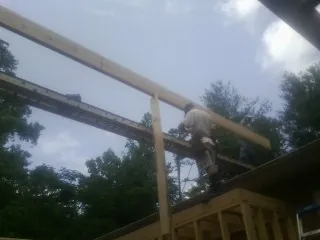 Carpenter setting a ridge beam over a new addition frame — Ice Dam Removal by Roofing Brothers in Natrona Heights