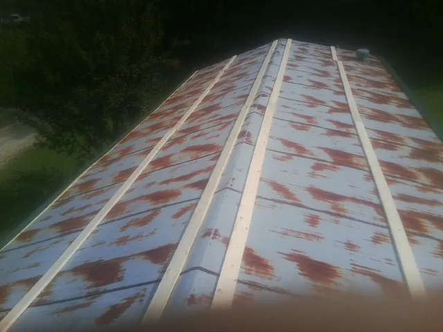 Rusted metal roof panels with new wood purlins before replacement — Storm Damage Roof Repair in Natrona Heights by Roofing Brothers