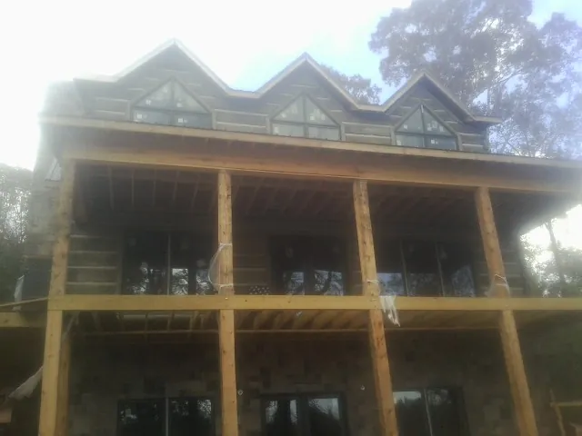 Dormers and porch framing on a large log home under construction — Roof Coating work by our crew in Natrona Heights