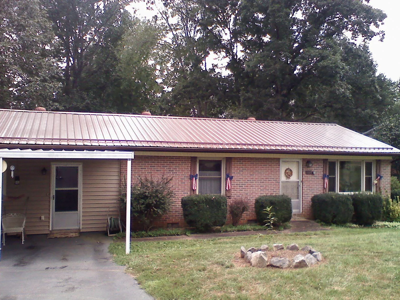 Bronze metal roof and carport on a brick ranch home — Roof Repair work by our crew in Natrona Heights