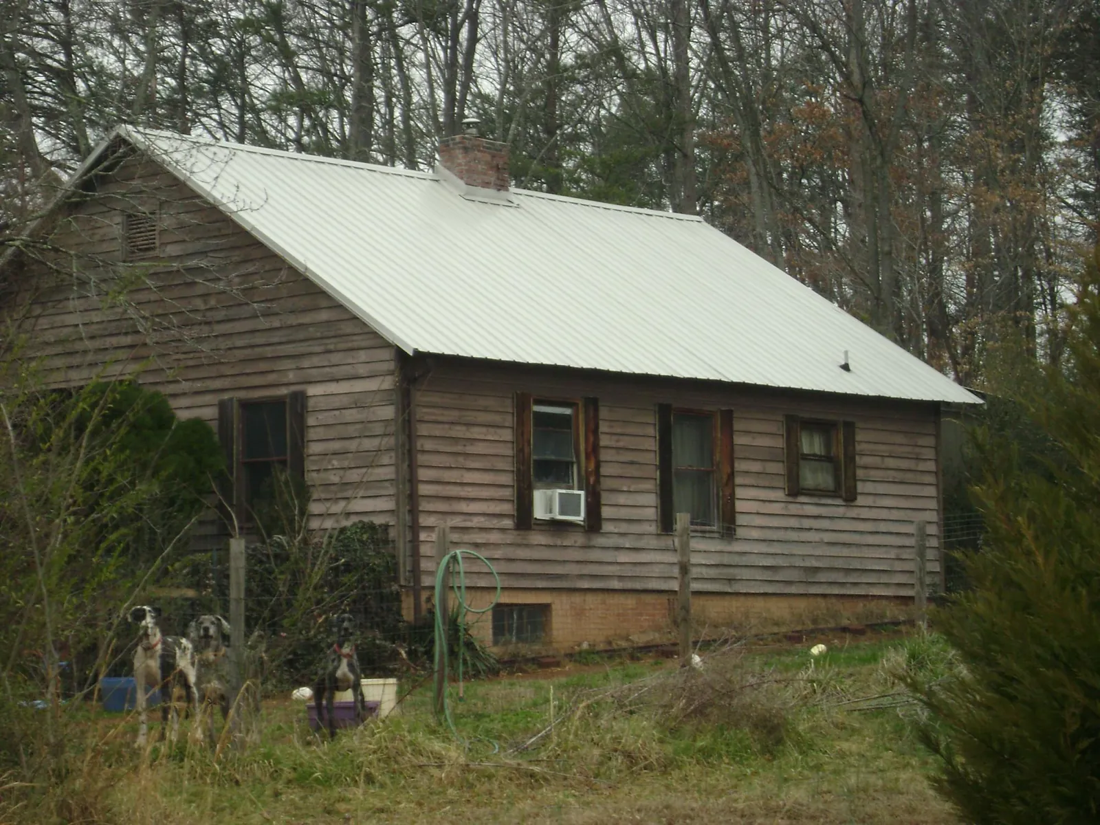 White metal roof on an old wood sided farmhouse, from a Metal Roof Installation job in Natrona Heights